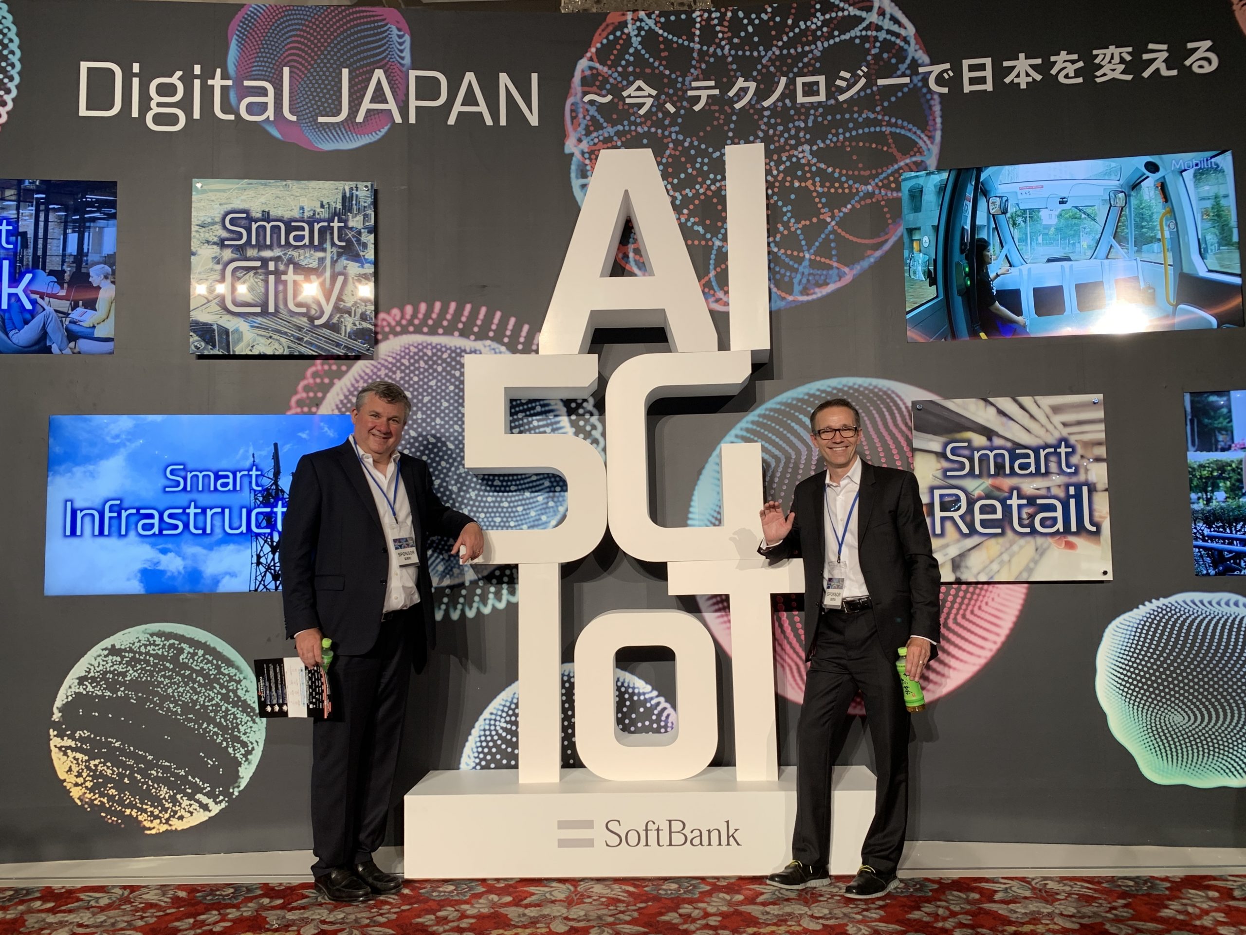 Blaine and Miguel of VANTIQ pose in front of SoftBank sign