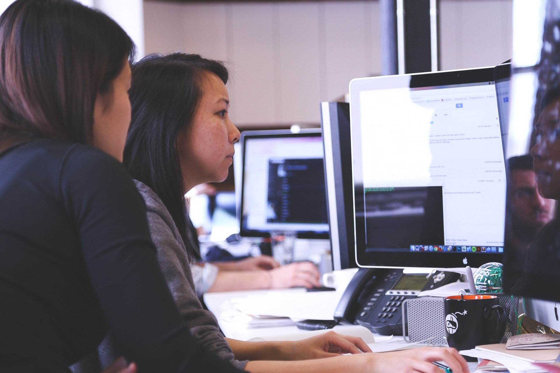 two female employees working in front of the computer in the office